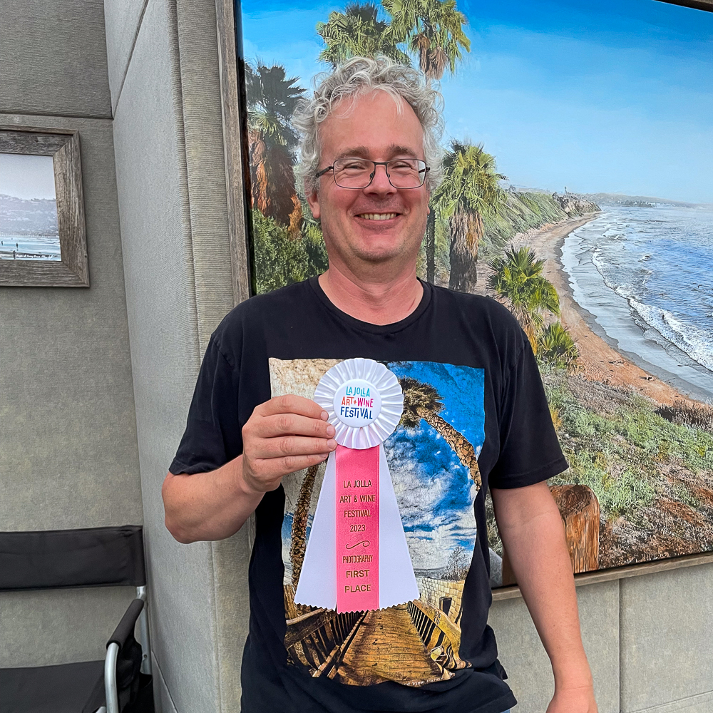 Roy holding ribbon for first place in photography at la jolla art and wine festival