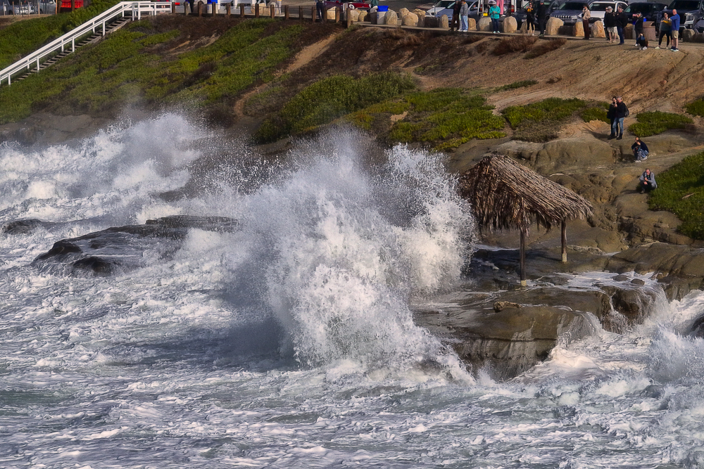 BIg waves crashing into bluffs at the Windansea Shack in La Jolla viewed from ocean
