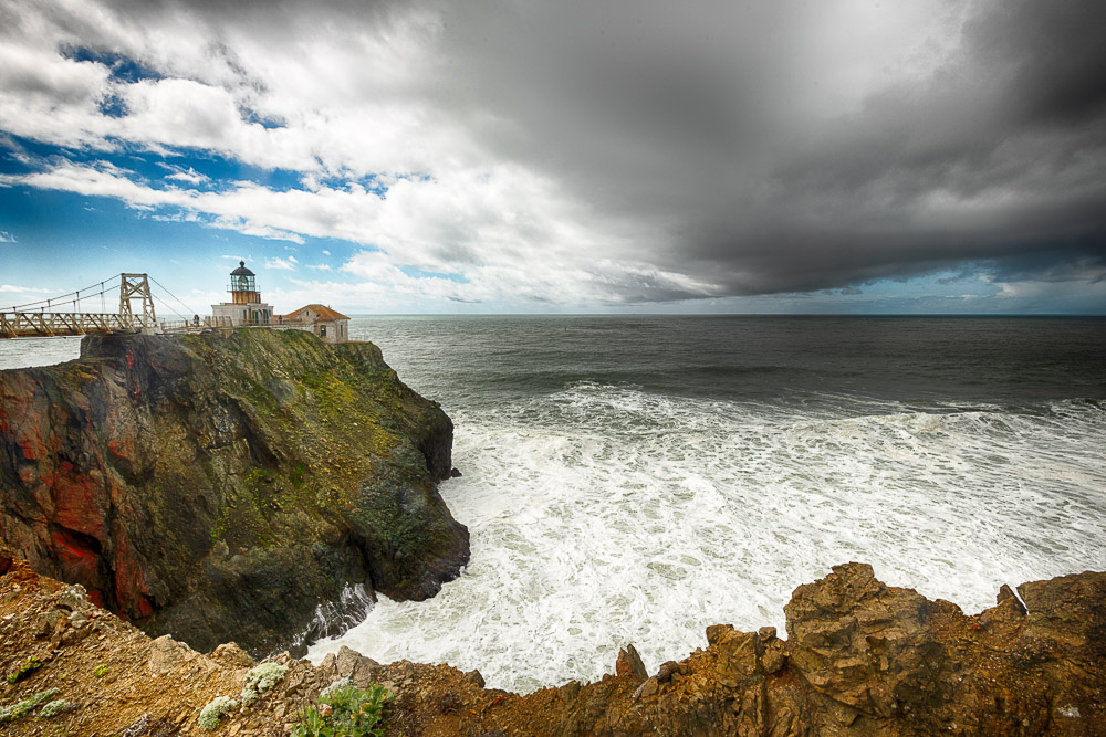 Point Bonita lighthouse with foamy ocean and dark clouds