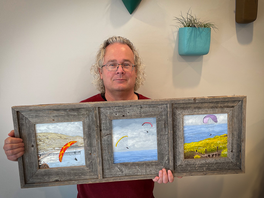 roy kerckhoffs holding oil painting triptych of la jolla gliders