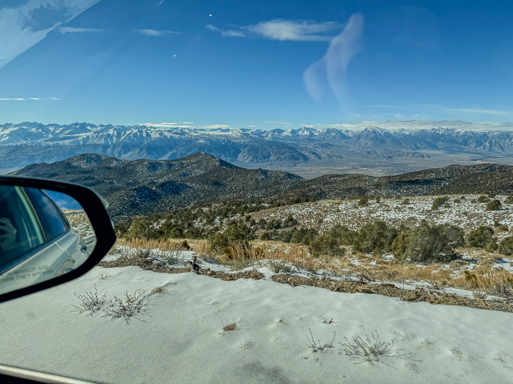 view from car on snow covered road of eastern sierra in bristlecone pine forest